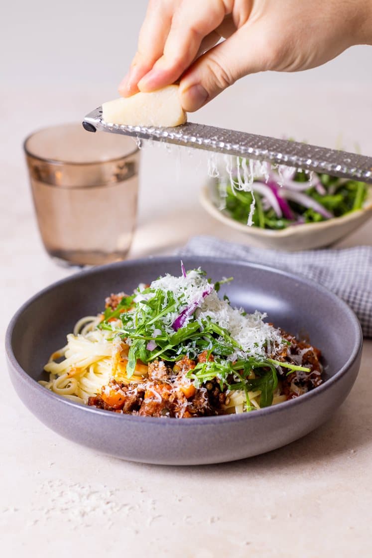 Rask pasta bolognese med tomat- og ruccolasalat, pinjekjerner og Grana Padano
