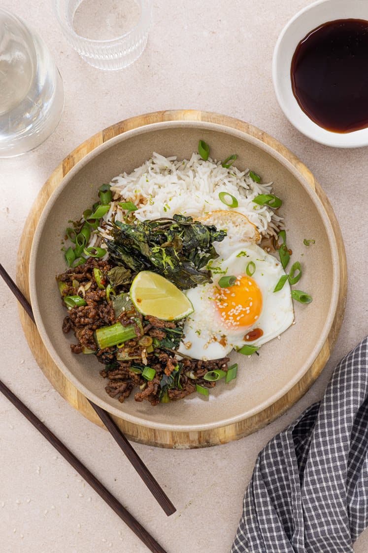 Koreansk bowl med hoisinstekt kjøttdeig, pak choy og spinatchips, servert med speilegg og vårløk