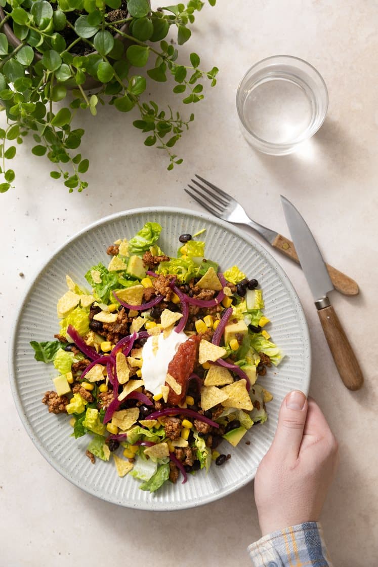 Tacosalat med mais, avokado og syltet rødløk, toppet med sprø tortillachips