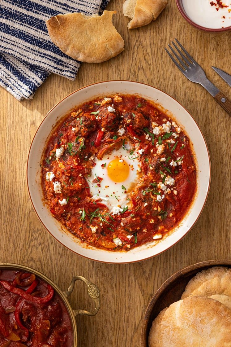 Marokkansk Shakshuka- tomatsaus med kjøttboller, egg og varme brød, toppet med fetaost