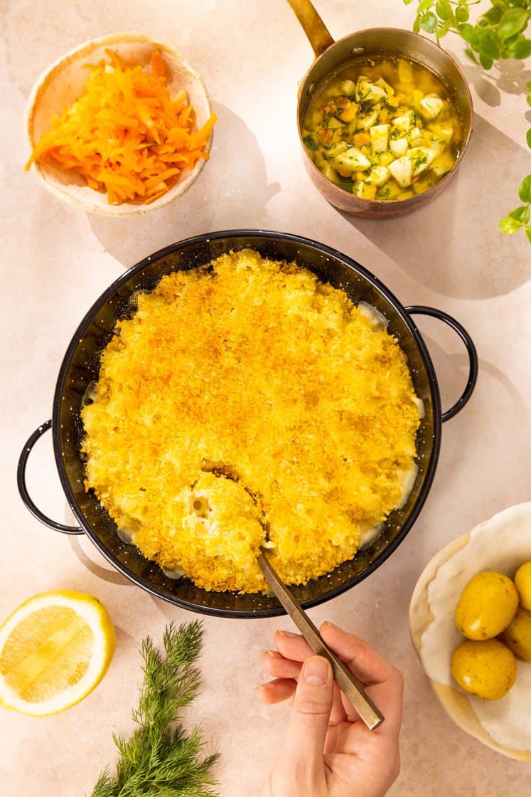 Fiskegrateng med kokte poteter og råkostsalat med eple, servert med eggesmør