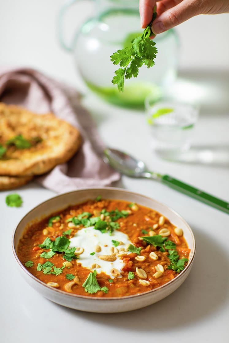 Indisk linseuppe med koriander og yoghurt, servert med nanbrød og nøtter