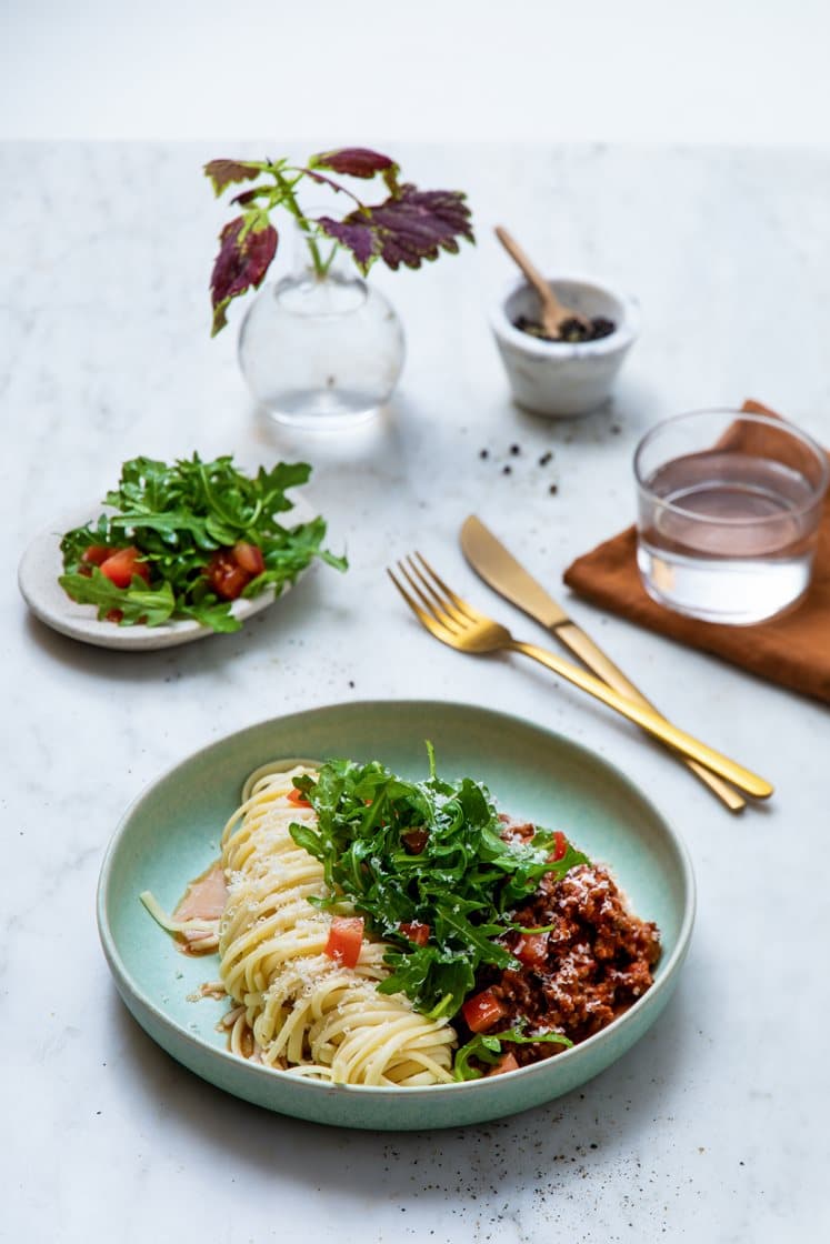 Rask pasta bolognese med tomat- og ruccolasalat, pinjekjerner og Grana Padano