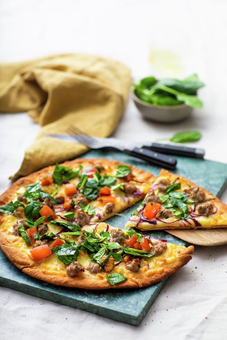 Pizza bianca med mozzarella og salsiccia, servert med tomat- og spinatsalat