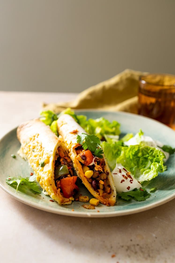 Gratinerte enchiladas fylt med bønner og paprika, servert med grønn salat og koriander