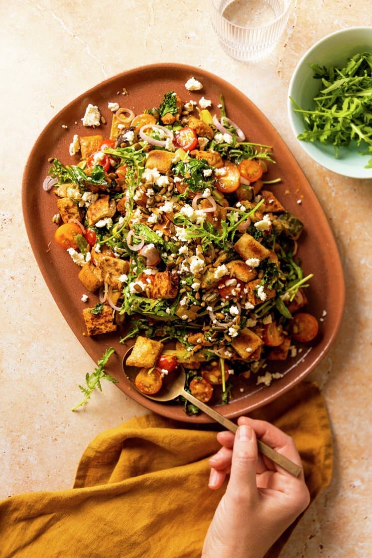 Panzanellasalat med aubergine og paprika, servert med fetaost og sprø kjerner