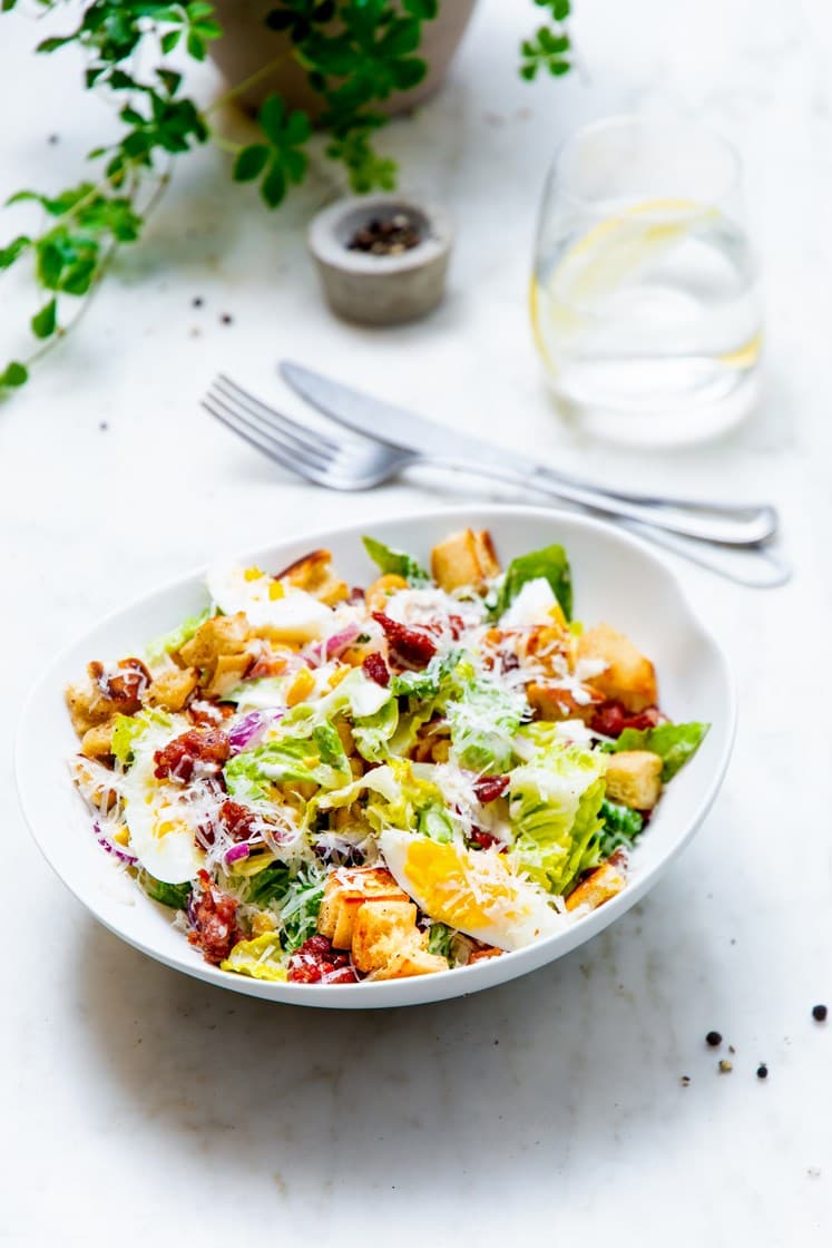Blandet salat med sprøstekt bacon, bløtkokte egg, brødkrutonger og Grana Padano