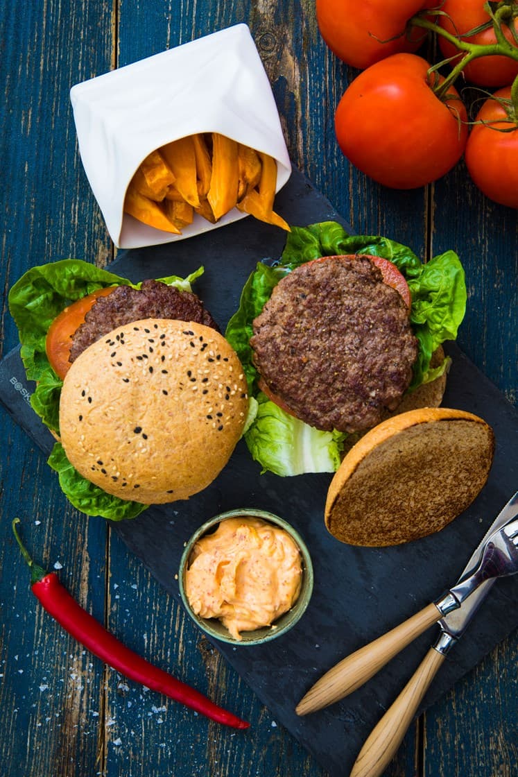 Hamburgere med chilimajones, salat, tomat og rødløk servert med søtpotetfries