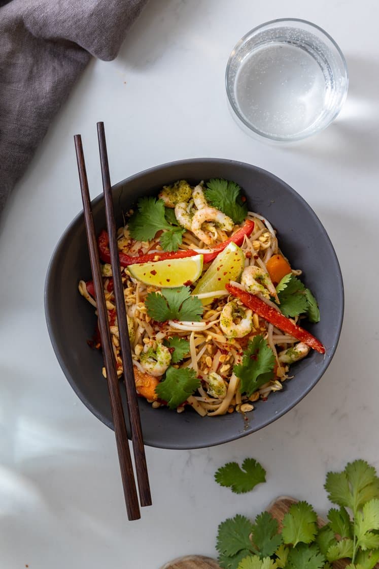 Pad thai med reker og eggenudler, servert med bønnespirer, peanøtter og koriander