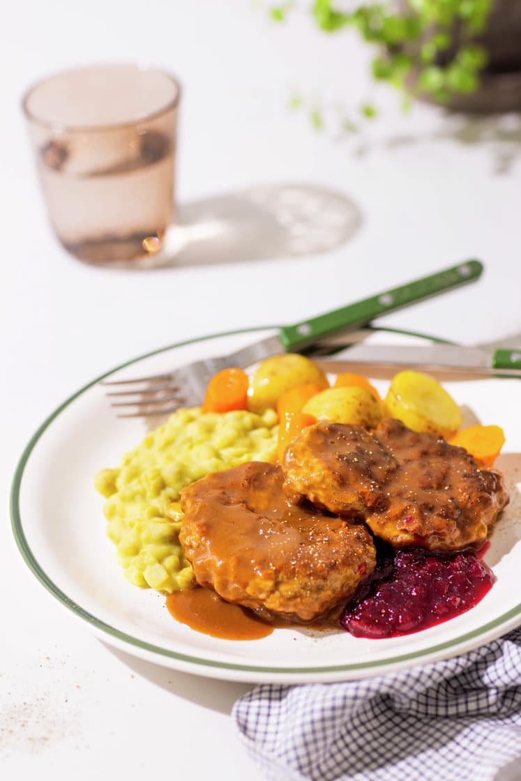 Elgkarbonader i brun saus med kokte poteter, gulrøtter, ertestuing og rørte tyttebær