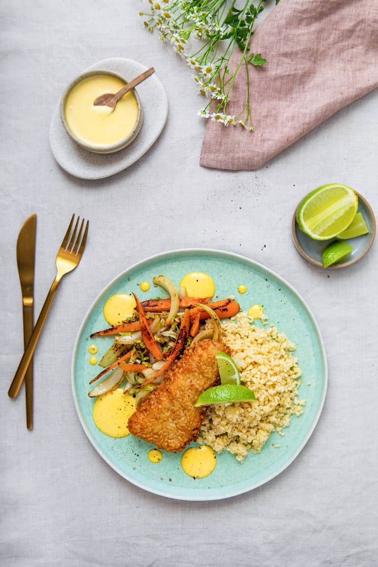 Panert torsk med bulgur og ingefærstekte grønnsaker, servert med curry- og mangodressing