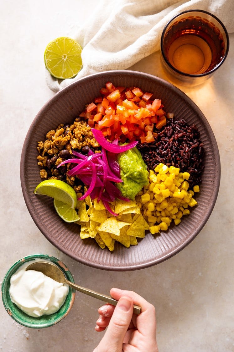 Meksikansk bowl med krydret kyllingkjøttdeig, syltet rødløk, avokadohummus og tortillachips