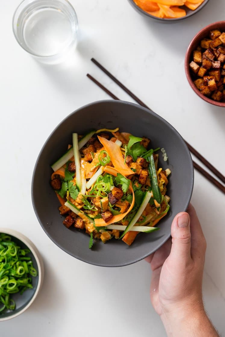 Hoisinstekt tofu og eggnudler i spicy chili- og peanøttsaus, toppet med vårløk og koriander