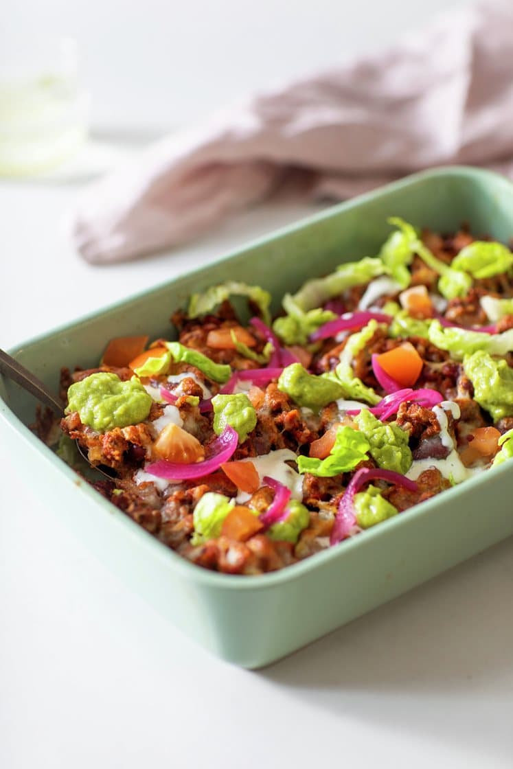 Ostegratinerte nachos med chili con carne, toppet med syltet rødløk, salat og guacamole