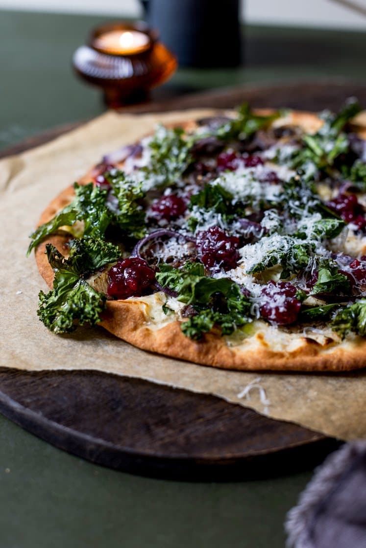 Hvit pizza med villhjorteskav, sopp og sprø grønnkål, toppet med rørte tyttebær og lagret ost 