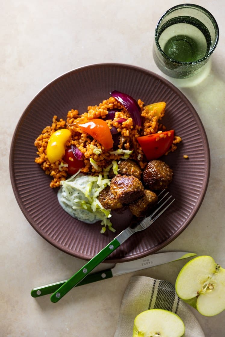 Kjøtt- og grønnsakskjøttboller og tomatbulgur med paprika og løk, servert med epletzatziki