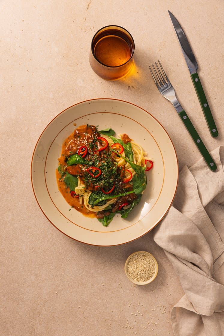Pasta linguine og kremet spicy sopp servert med sesmfrø, spinat og persille