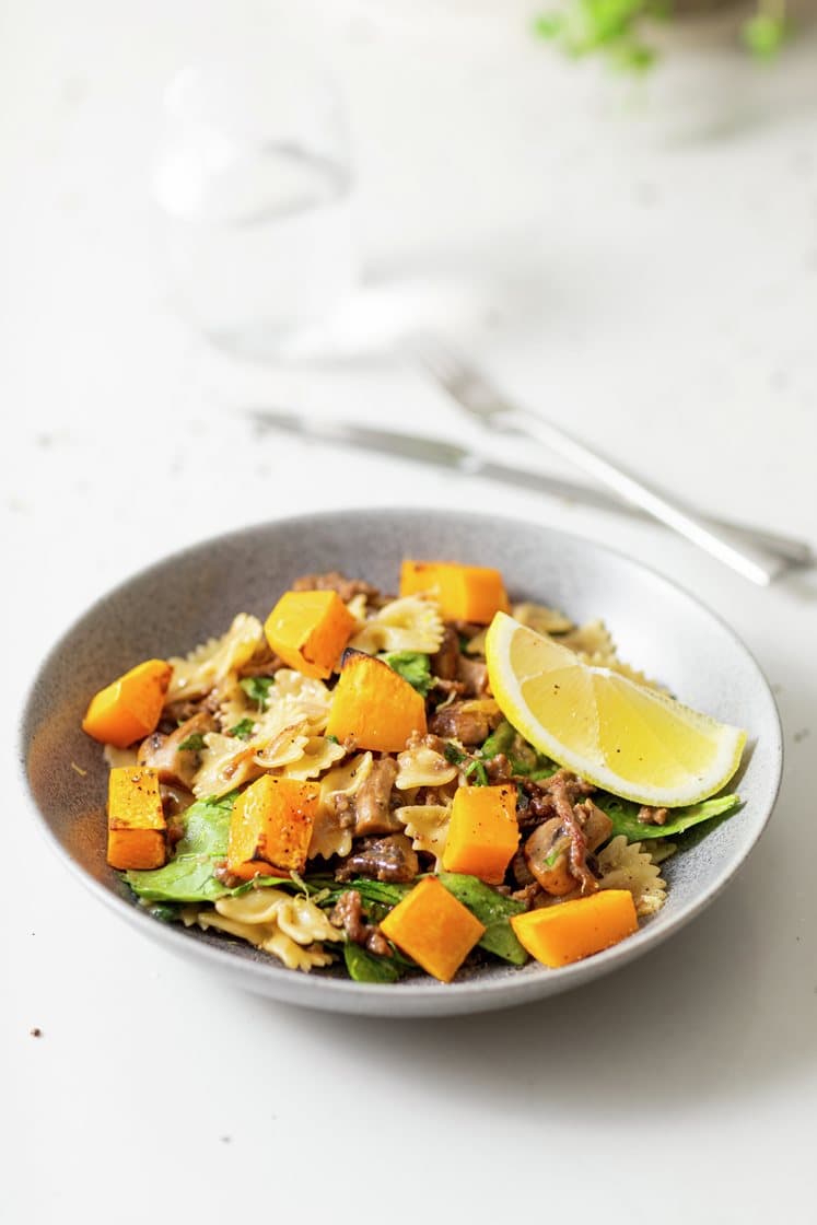 Pasta i kremet soppsaus med spinat, stekt kjøttdeig og aromasopp, servert med ovnsbakt gresskar