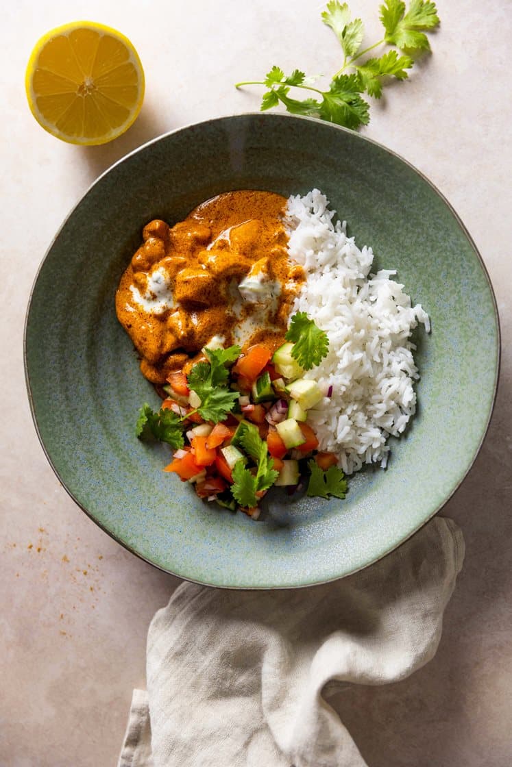 Indisk butter chicken med basmatiris og kachumbersalat, servert med raita