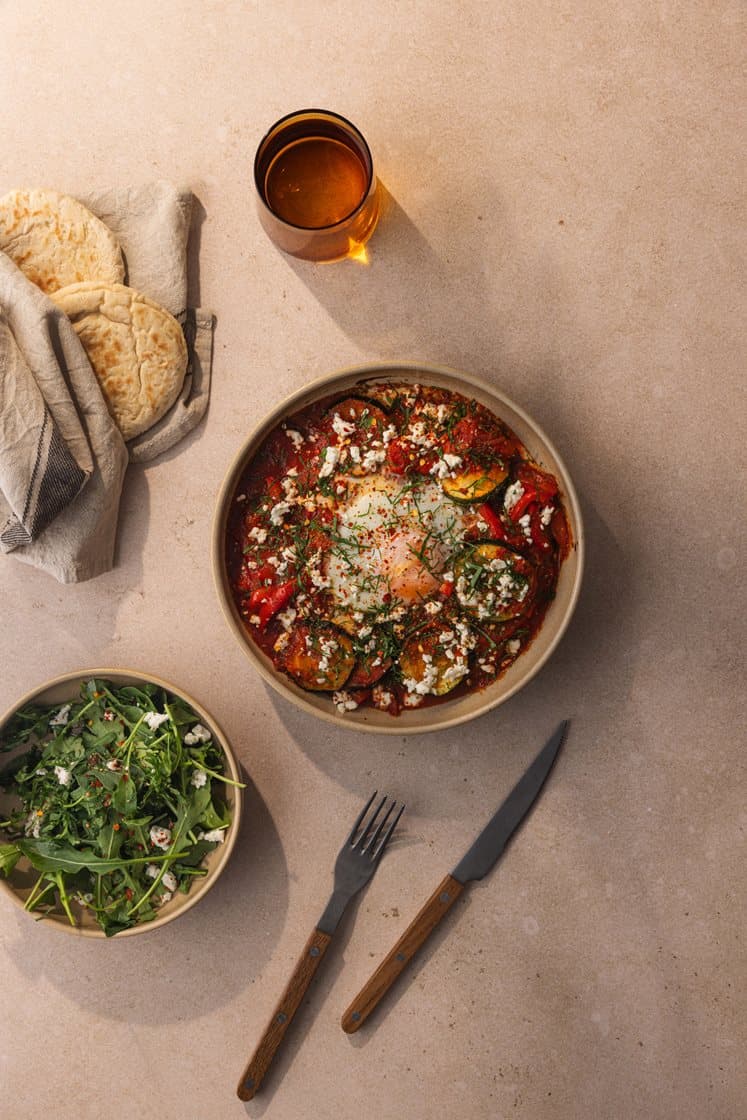 Shakshouka - egg i tunisisk tomatsaus, servert med varme brød, persille og fetaost