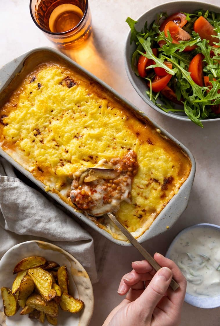 Gresk auberginegrateng med grønne linser, servert med tomatsalat og urtedressing