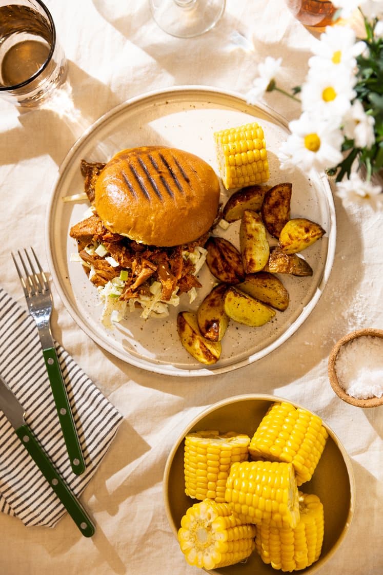 Pulled jalapeño pork-burger med barbecuesaus, servert med eple-coleslaw, mais og potetbåter