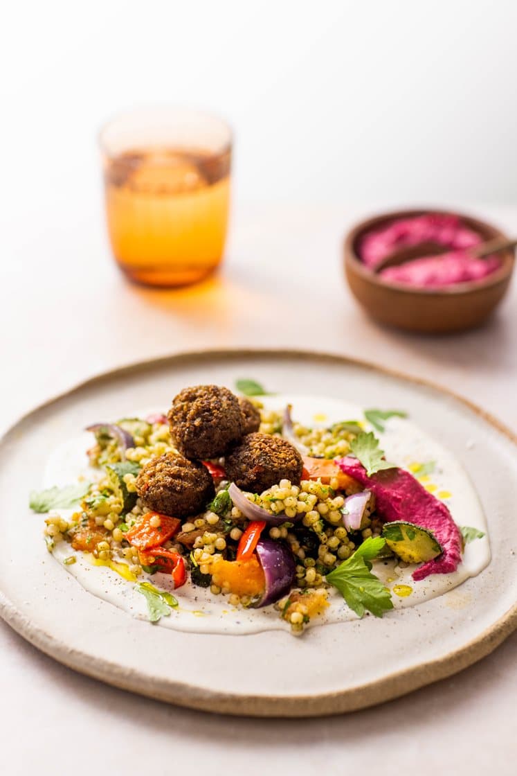 Falafler med varm perlecouscoussalat, servert med rødbetehummus og hvitløksdressing