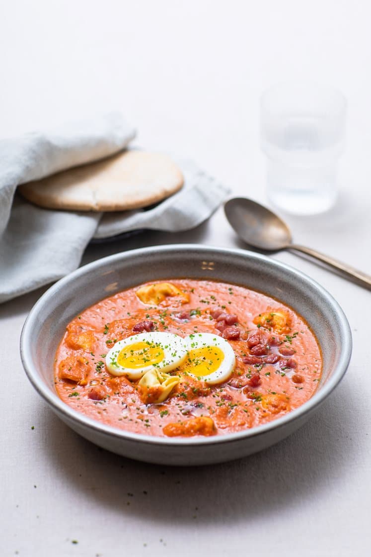 Tomatsuppe med tortelloni og egg, servert med sprøstekt bacon og varme brød