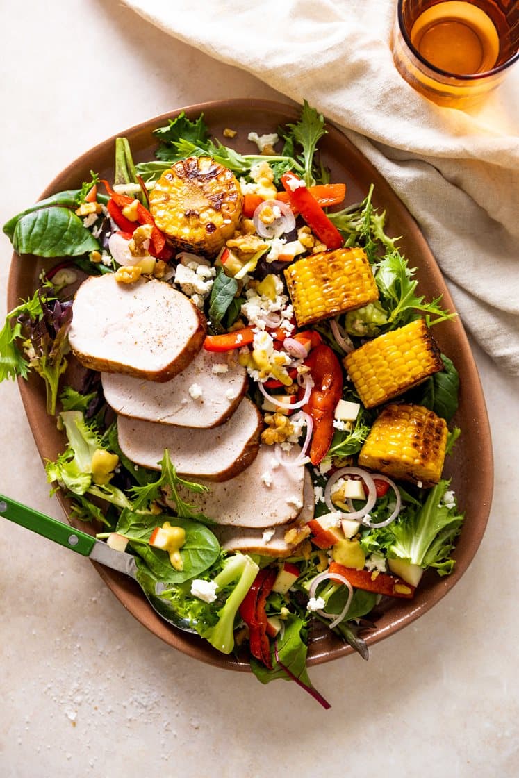 Filetstykke av svin med paprika og mais, servert med nektarin- og fetaostsalat med valnøtter 