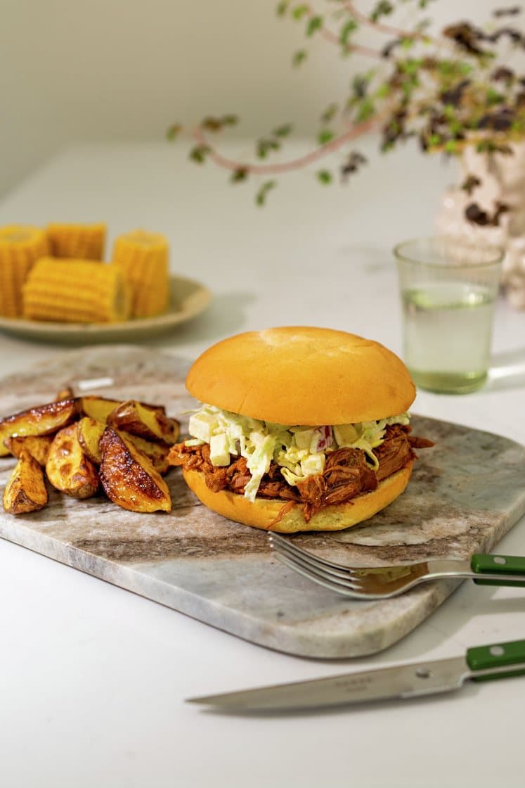 Pulled jalapeno pork-burger med barbecuesaus, servert med eple-coleslaw, fersk mais og potetbåter
