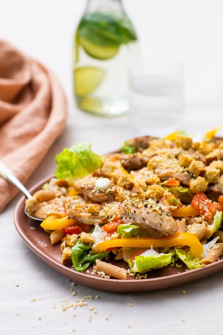 Pastasalat med kylling, tomat og cæsardressing, toppet med urtekrutonger