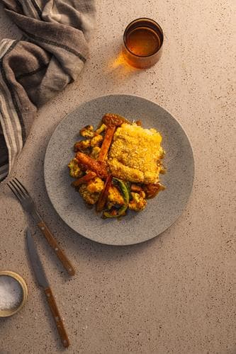 Fiskegrateng med karristekte gulrøtter og blomkål, servert med løksmør