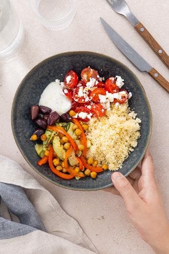 Marokkansk bowl med bakte grønnsaker, couscous, krydret yoghurt og tomatsalat med fetaost