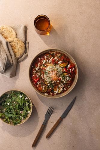 Shakshouka - egg i tunisisk tomatsaus, servert med varme brød, persille og fetaost