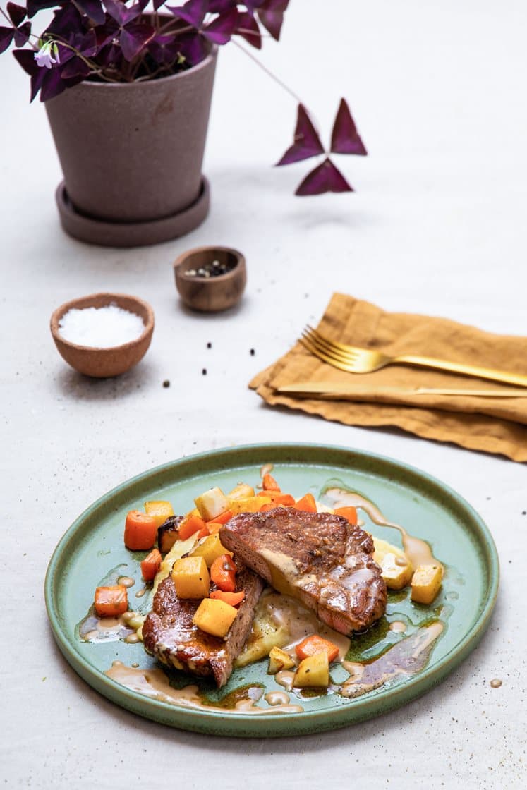 Krydderstekt svinenakke med ovnsbakte rotgrønnsaker, potetmos, soppsaus og rørte tyttebær