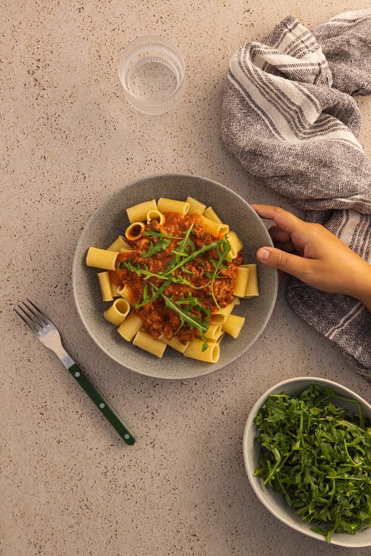 Kremet pastagryte med tomat- og kjøttsaus, ruccola og mozzarella