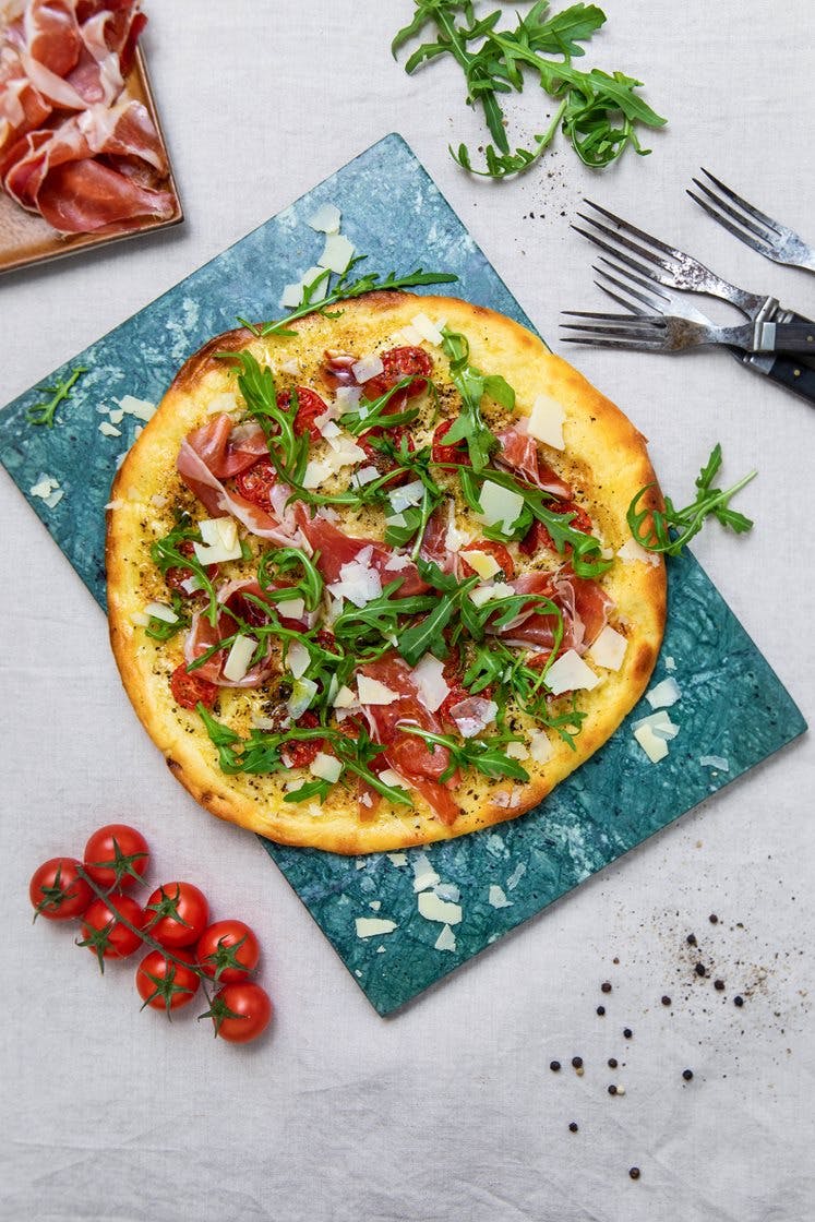 Steinovnsbakt pizza bianca med parmaskinke, søte tomater, ruccola og Grana padano