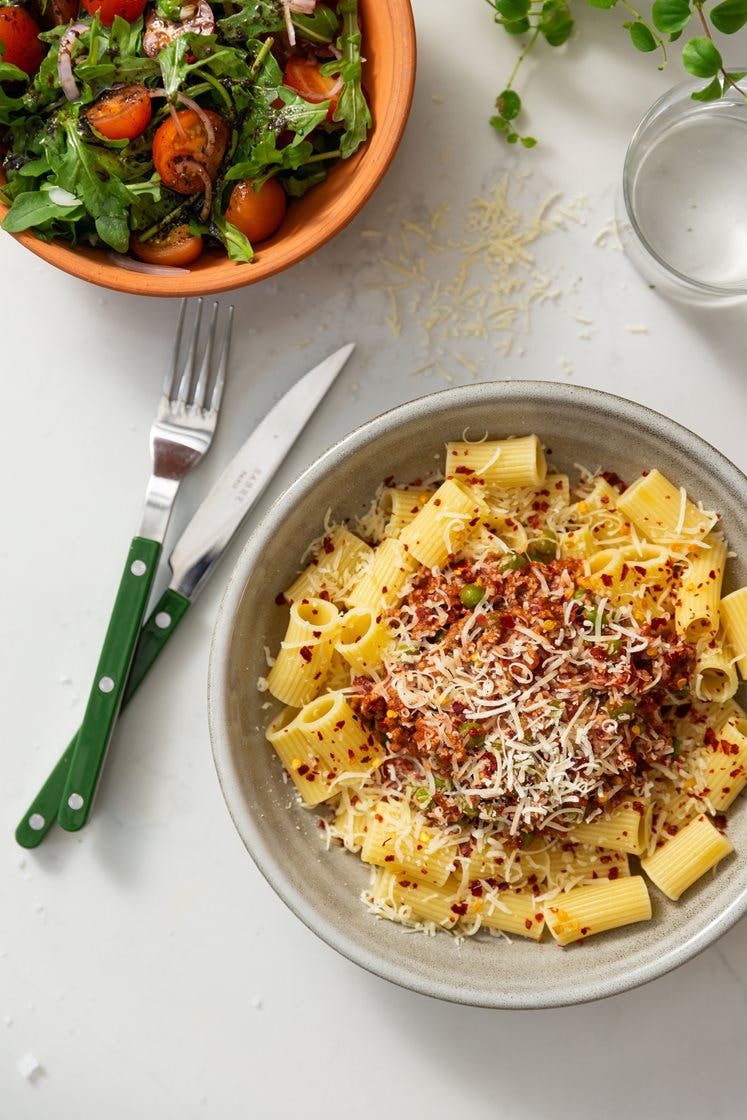 Rask pasta bolognese med tomat- og ruccolasalat, pinjekjerner og Grana Padano