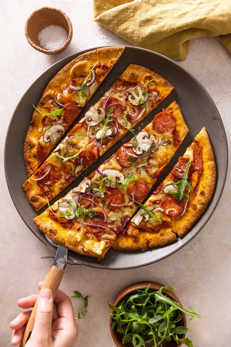 Pepperonipizza med aromasopp og rødløk, toppet med ruccolasalat