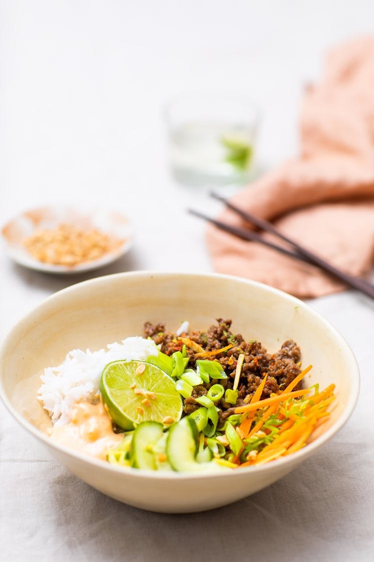 Rice bowl med hoisinstekt kjøttdeig, vårløk, lettsyltet agurk, chilimajones og peanøtter