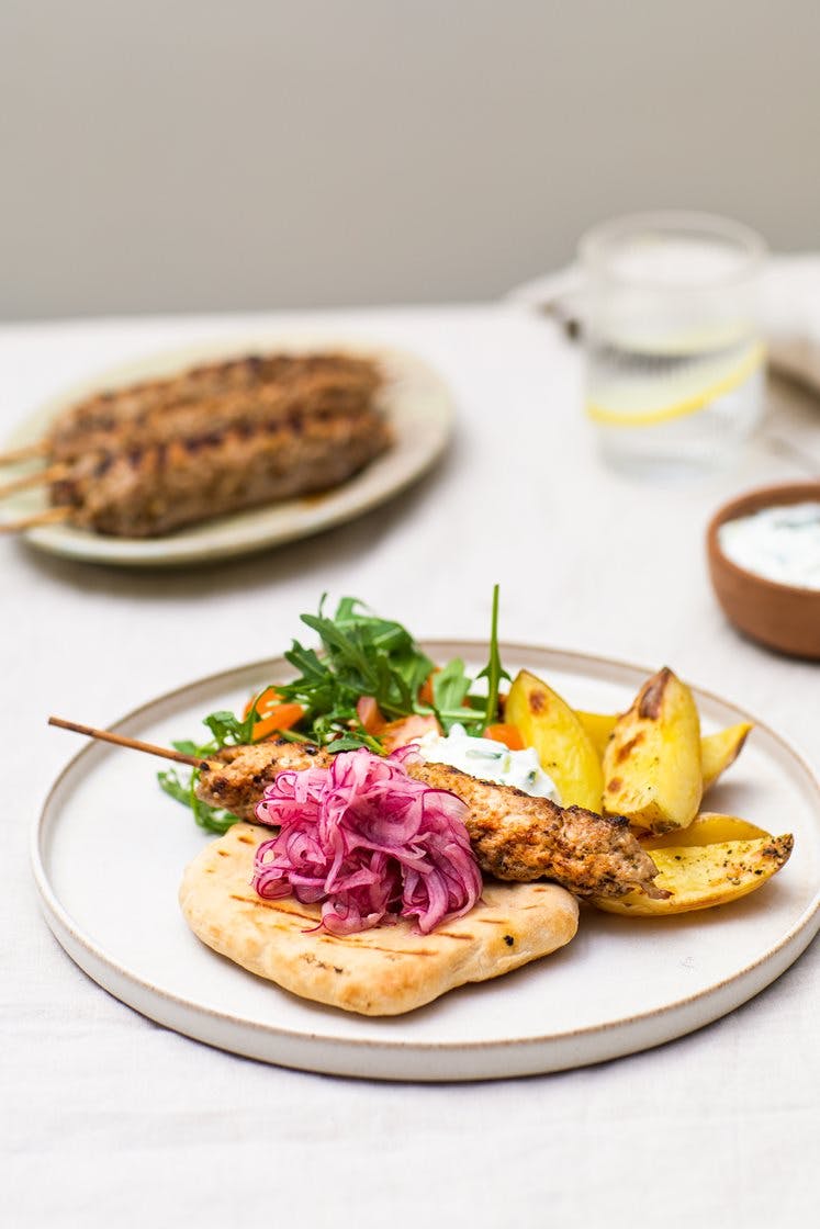 Adana-kebab med potetbåter, råmarinert løk, yoghurtdressing og varme multibrød