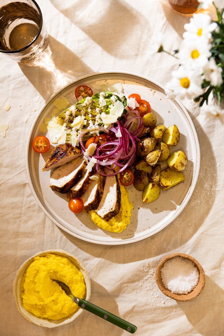 Kyllingbryst med maiskrem, hjertesalat i cæsardressing, potetchunks og marinert rødløk