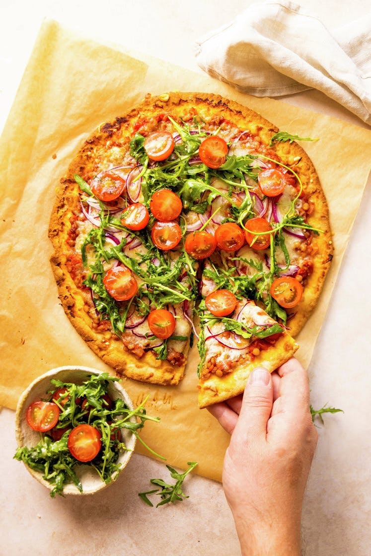 Pizza bolognese med linser og Grande Premium-ost, servert med ruccola- og tomatsalat