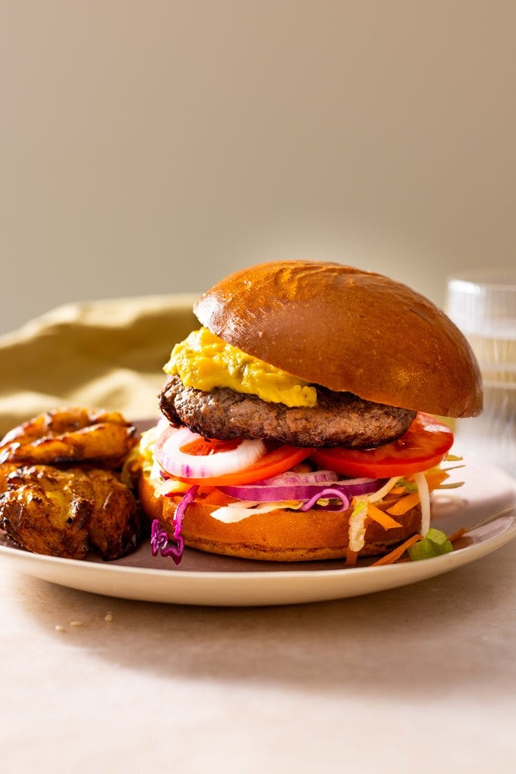Hamburger i briochebun, med syrlig kålsalat, maiskrem og knuste sprø poteter