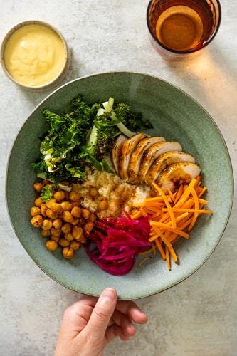 Couscous- og kikertbowl med kylling i soya- og ingefærsjy, sprøstekt grønnkål og curry- og mangodressing